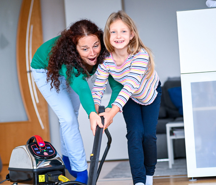 Mum and daughter have fun mopping the floor together with the ThermostarMutter und Tochter haben Spaß dabei, gemeinsam mit dem Thermostar den Boden zu wischen.