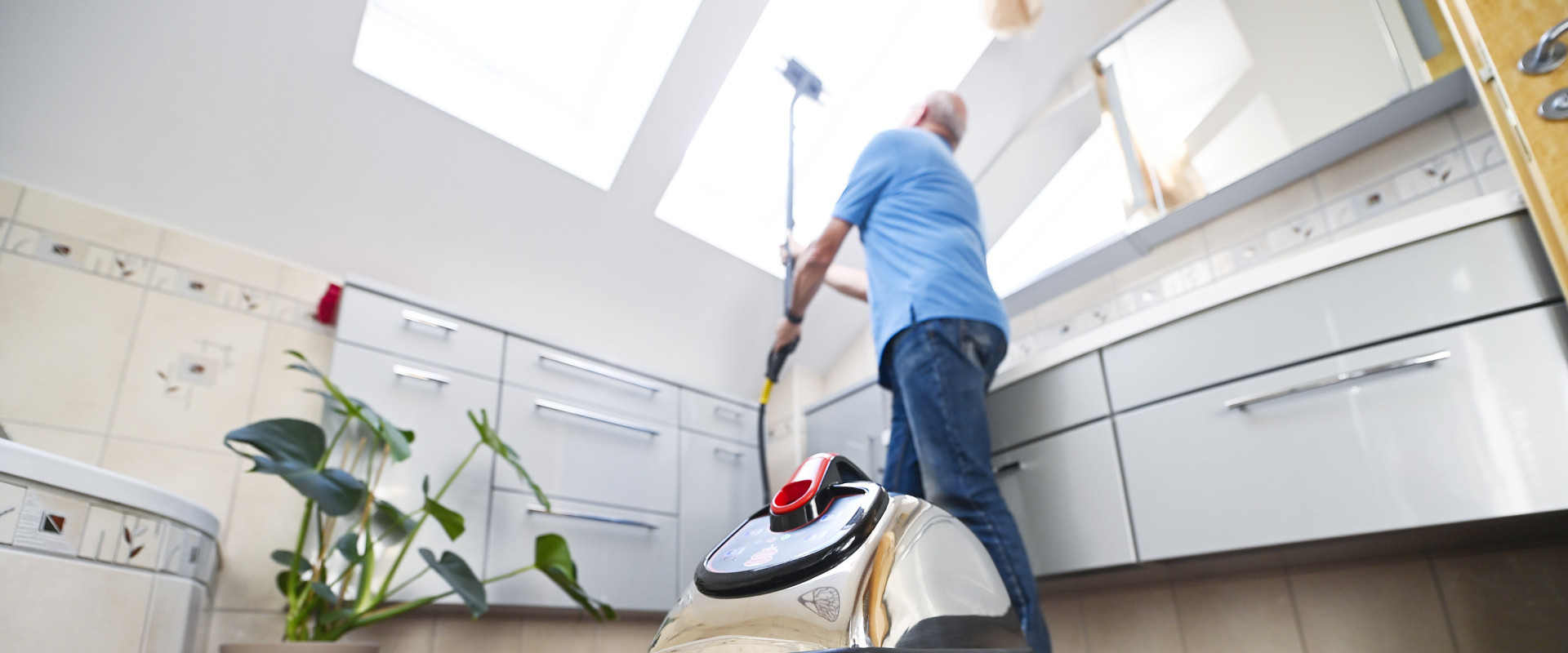 Älterer Mann reinigt Dachfenster von innen ohne Leiter ganz einfach mit den Thermostar-Verlängerungen